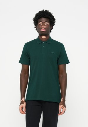 Donkergroene poloshirt van gestructureerde stof, met een knoopsluiting van drie knopen en een klein geborduurd logo op de linker borst.