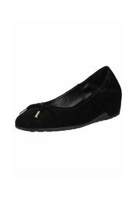 Chaussure plate en suède noir avec un bout arrondi, ornée d'un nœud et de deux accents dorés à l'avant. Elle est dotée d'un talon compensé bas.