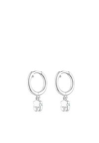 Orecchini a cerchio in argento con charm a forma di orso pendente e incisione "TOUS". Il charm è sagomato come un orsetto con una finitura lucida.
