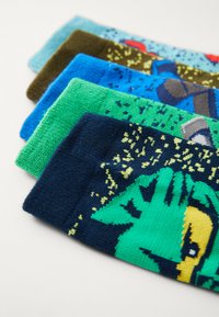 Fünf Paare bunter Socken in Blau, Grün und Braun, mit verschiedenen Mustern und Texturen, darunter Grafiken auf einem weichen Strickmaterial.