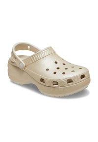 Beige klompen van gevormd plastic, met ventilatiegaten en een achterband. Gelaagd bovenwerk met een glanzende afwerking en verhoogde randen.