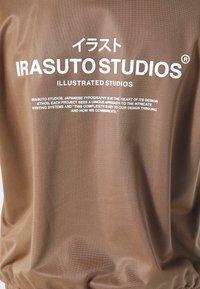 Bruine stof met witte tekst in Japanse karakters, een gladde textuur en een ontspannen ontwerp. Inclusief het merk "Irasuto Studios."