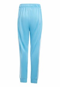 Pantalones deportivos azul claro de tejido suave, con una banda elástica en la cintura y rayas blancas a lo largo de los lados. Puños en los tobillos.