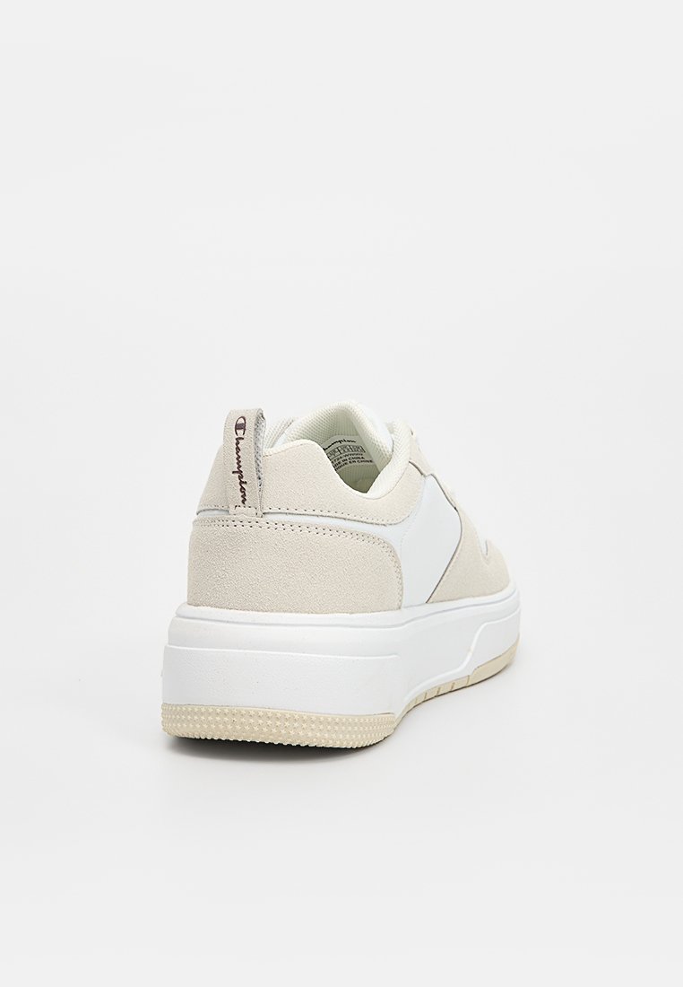 Zapatilla blanca y beige con parte superior de ante y sintético, puntera redondeada, cuello acolchado y suela de goma texturizada.