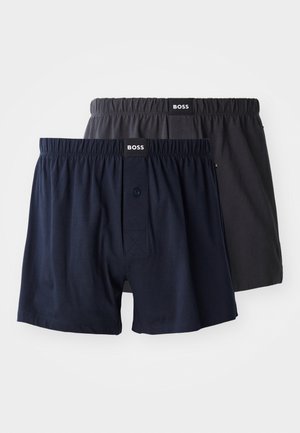 Zwei Paare Baumwoll-Boxershorts, eines in Marineblau und eines in anthrazitgrau, mit elastischen Taillenbündchen und einem Knopfdetail vorne.