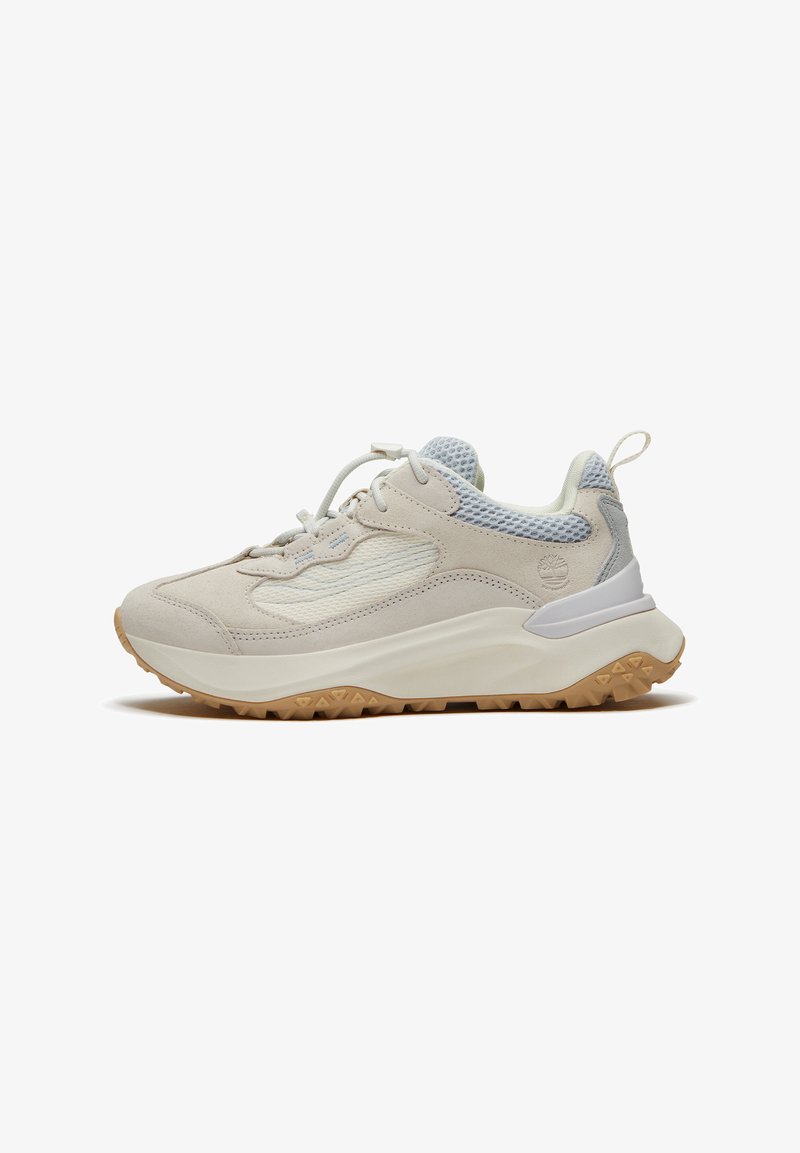 Sportovní teniska v béžové a světle šedé barvě s horní částí z síťoviny, robustní bílou podrážkou, gumovým vzorkem, poutkem na patě a tkaničkami.