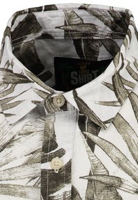 Camisa de manga corta con cuello abotonado, que presenta una tela blanca con patrones de hojas en verde y gris y un botón de color claro.