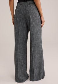 Széles lábú nadrág texturált sötétszürke anyagból, finom mintázattal. Jellemzői közé tartozik egy övrész és két hátsó zseb a praktikum érdekében.