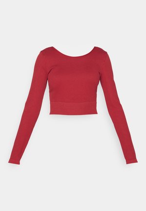 Red, ribbed long-sleeve crop top with a rounded neckline and fitted waist. Features a smooth texture and minimal design.