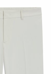 Ljusbeiga byxor gjorda av texturerad väv, med flat front, bältesöglor och ett subtilt diagonalt mönster.