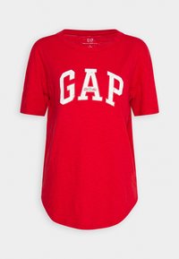 T-shirt rouge en coton à manches courtes avec ourlet arrondi et grand lettrage blanc "GAP" sur la poitrine.