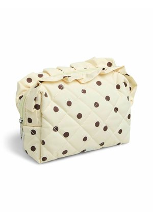 Pochette matelassée couleur crème avec des pois marron, fermeture éclair et bordure volantée tout le long du bord supérieur.