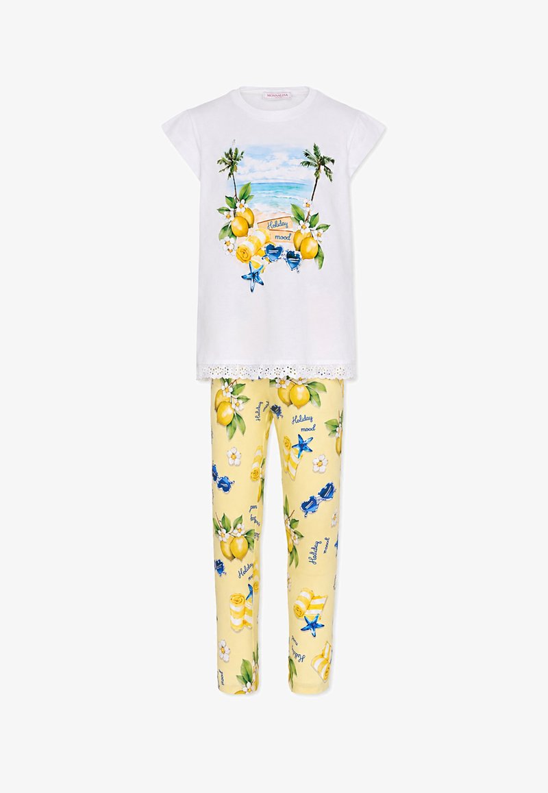 Top blanco de manga corta con escena de playa, limones y texto "holiday mood", combinado con pantalones amarillos con estampado de limones, flores y gafas de sol.