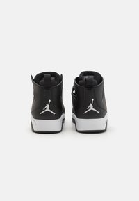 Sorte høyhælte joggesko med lær overdel, hvit mellomsåle og Jumpman-logo på hælen. Har polstret krage og anklestøtte.