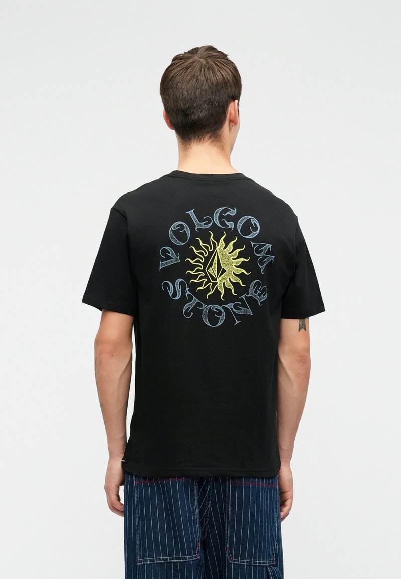 Zwarte katoenen t-shirt met een kleurrijk zonontwerp en de tekst "Volcom Stone" in een cirkelindeling op de achterkant. Korte mouwen, ronde hals.