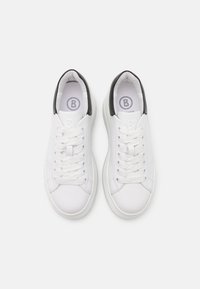 Vita lädersneakers med rund tå, platta snören och svarta häldetaljer. Har ett texturerat mönster på tungan och sidorna.