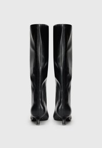 Black leather knee-high boots with kitten heels shown from the back on a plain light gray background.