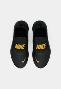 Juodi Nike basutės yra su tekstūruotu viršumi, papuoštu auksiniais akcentais ir ryškiu logotipu, papildytos dėmėtu padu, suteikiančiu papildomą detalumą.