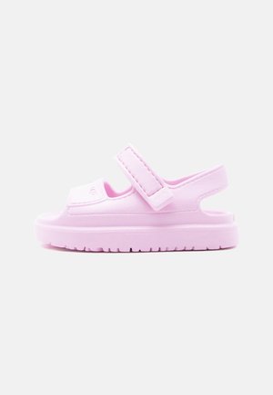 Sandalia rosa claro de punta abierta con suela gruesa, correas ajustables de velcro sobre el pie y alrededor del talón, exhibida sobre fondo blanco.