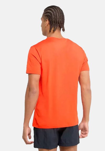 Camiseta naranja de manga corta hecha de una tela suave, con un cuello redondo clásico y un corte relajado, vista desde la parte de atrás.