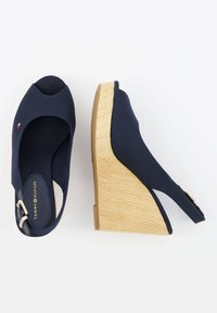 Sandali a zeppa navy con punta aperta, tomaia in tessuto, tacco in sughero con texture in juta e cinturino alla caviglia regolabile con una fibbia metallica.