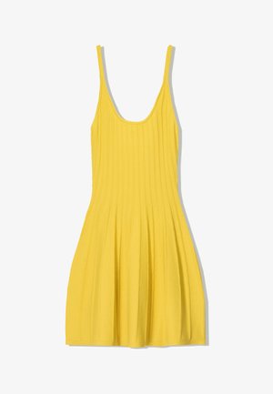 Gul ribbade klänning med tunna band, åtsittande liv och skattad plisserad kjol. Tillverkad av texturerat tyg, har en rundad halsringning.