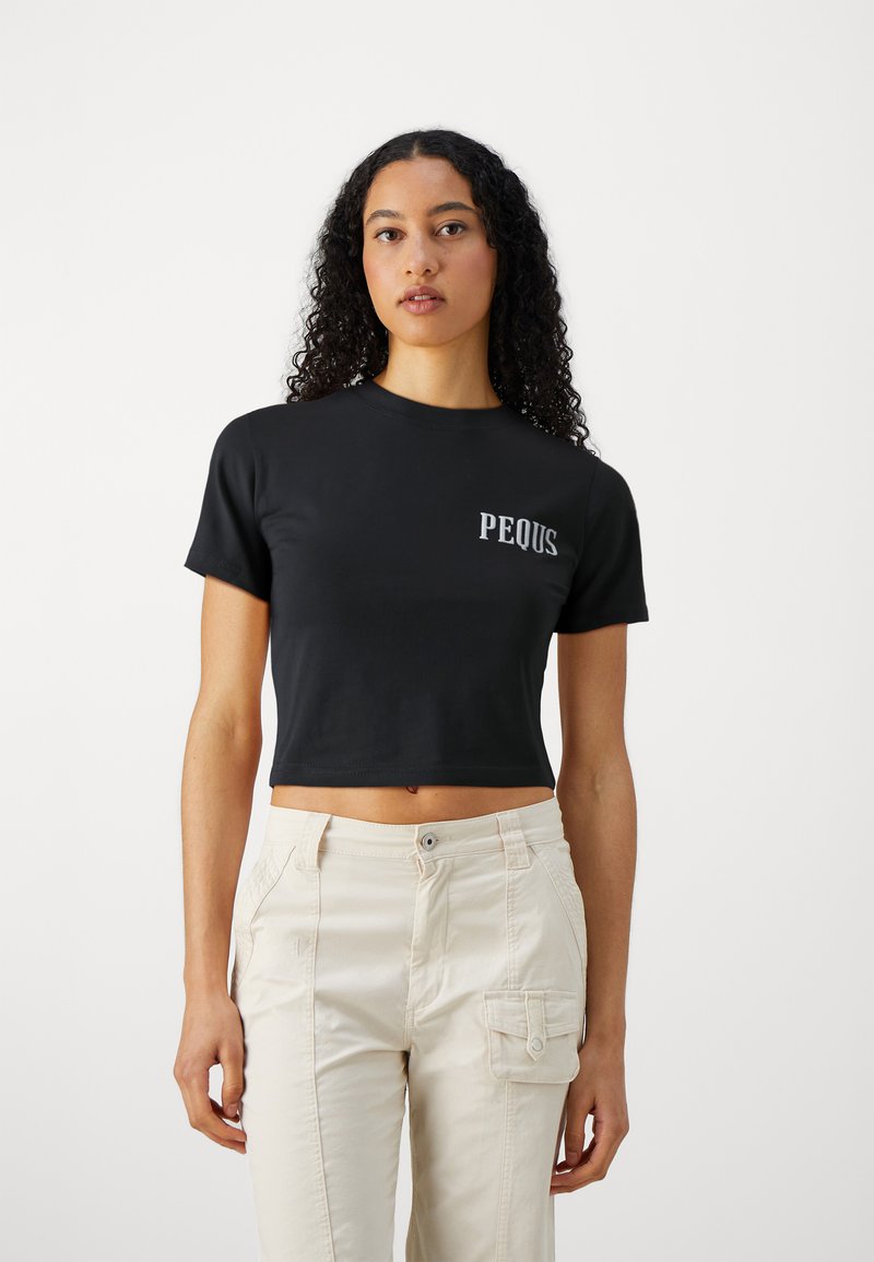 Svart kortärmad t-shirt med korta ärmar och "PEQUS" tryckt i vitt på vänster sida. Slät tyg, figurnära design.