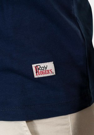 T-shirt in cotone navy con un piccolo etichetta bianca con la scritta "Roy Rogers" in rosso. Tessuto liscio con un classico scollo rotondo.
