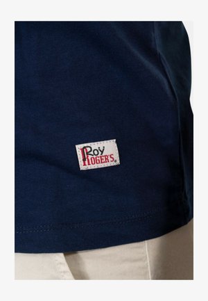 T-shirt in cotone navy con un piccolo etichetta bianca con la scritta "Roy Rogers" in rosso. Tessuto liscio con un classico scollo rotondo.