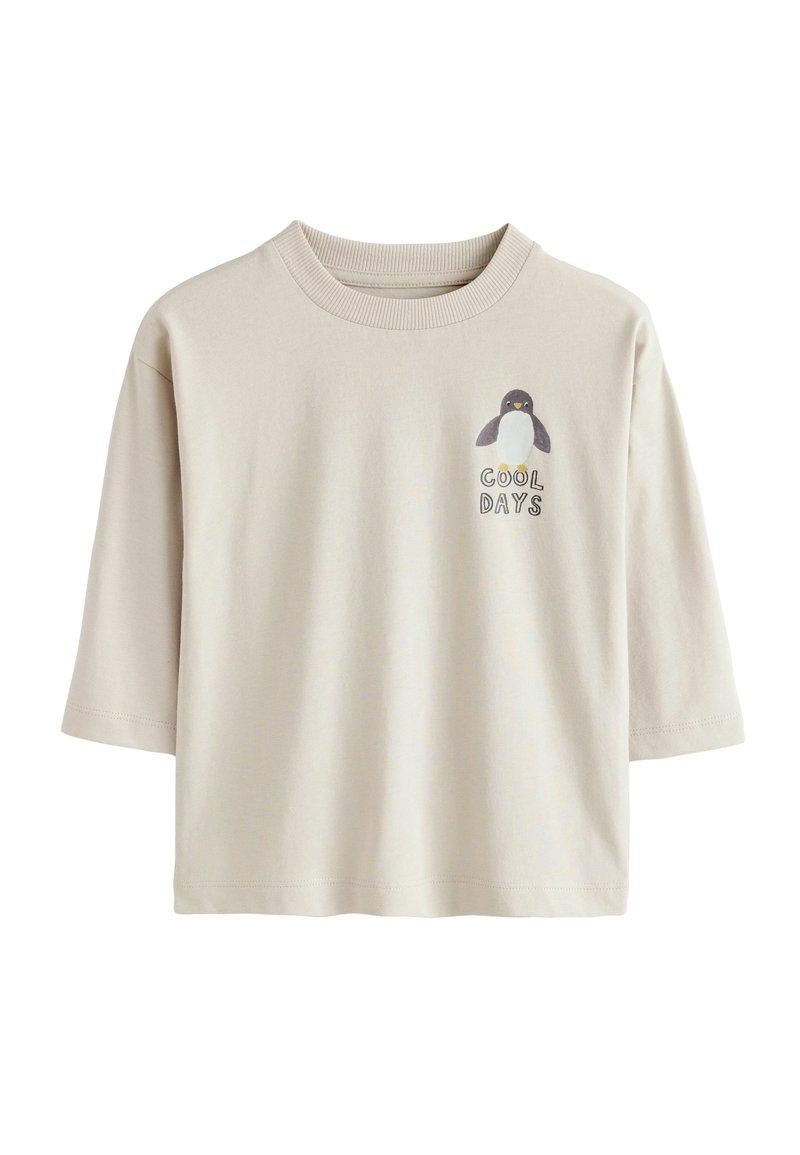 Bež majica s kratkimi rokavi iz bombaža, ki prikazuje grafiko pingvina in napis "HLADNI DNEVI" na levi strani prsnega dela.