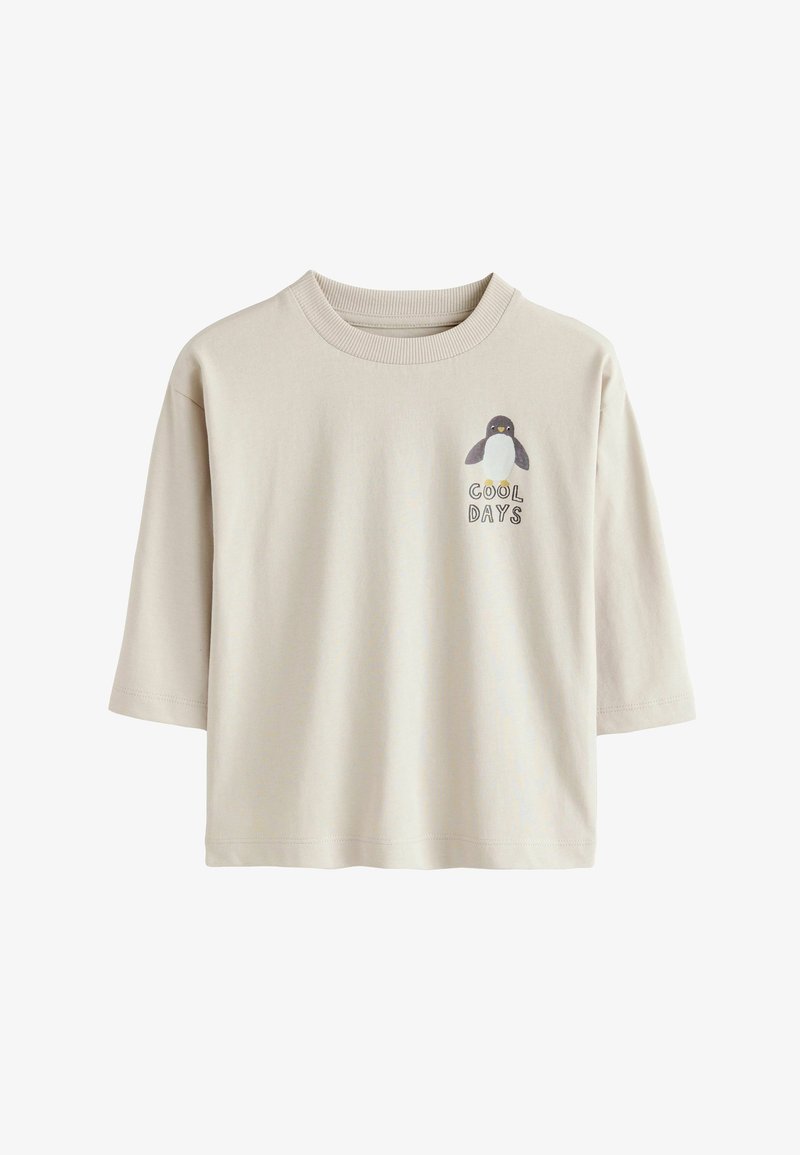 Bež majica s kratkimi rokavi iz bombaža, ki prikazuje grafiko pingvina in napis "HLADNI DNEVI" na levi strani prsnega dela.