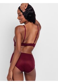 Dieprode lingerieset met een zachte stof, verstelbare bandjes en een haaksluiting aan de achterkant, gecombineerd met hooggetailleerde onderkleding.