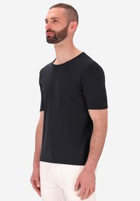 T-shirt nera a maniche corte realizzata in tessuto morbido con scollatura rotonda. La maglietta ha un design semplice e dritto. Nessun motivo o dettaglio visibile.