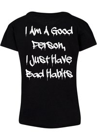 Sort bomulds t-shirt med en afslappet pasform, der har stor hvid tekst med teksten "Jeg er en god person, jeg har bare dårlige vaner" i en dryppende skrifttype.
