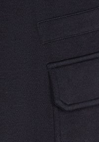 Marine stof met een zachte textuur; heeft een zak met een klep. Het materiaal ziet er glad en licht getextureerd uit.