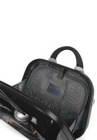Bolso negro con un acabado brillante, interior con patrón hexagonal, cierre de cremallera y un asa gris. Incluye una ventana para identificación y bolsillos elásticos.