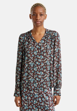Braunes Blumenshirt mit langen Ärmeln und V-Ausschnitt, verziert mit blauen und cremigen Blumen, weicher Textur und gerafften Details an den Schultern.