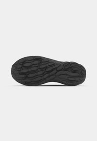 Black rubber shoe sole with a textured pattern of oval and curved shapes, designed for traction and durability.