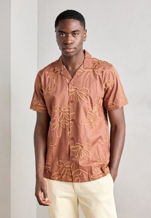Brown short-sleeve shirt featuring floral embroidery in a lighter shade, button-down front, and a typical collar design.