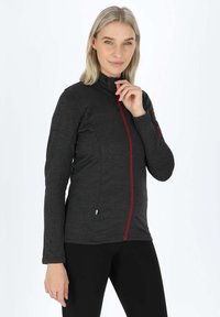 Giacca grigia con zip e dettagli rossi, colletto alto, maniche lunghe e materiale testurizzato. Presenta una tasca con zip sul braccio.
