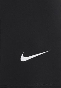 Zwarte sportieve stof met een gladde textuur; heeft een opvallend wit Nike swoosh-logo aan de voorkant.