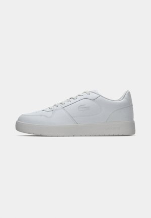 Weiße Lederturnschuhe mit grauer Gummisohle, runder Zehenpartie, flachen Schnürsenkeln und geprägtem Logo an der Seite. Glatte Textur und minimalistisches Design.