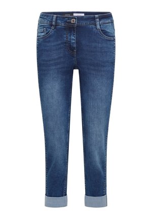Blå denimjeans med optrukne manchetter, forreste knap, lynlåslukning samt for- og baglommer, vist på ensartet hvid baggrund.