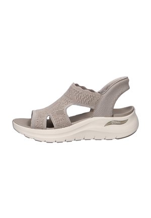 Sandale beige à bout ouvert avec bride arrière, tige tricotée, soutien de la voûte plantaire rembourré et semelle épaisse texturée pour le confort et la stabilité.