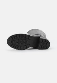 Czarna skórzana podeszwa buta z głębokim bieżnikiem dla lepszej przyczepności, z sześciokątnymi i okrągłymi wzorami, solidna konstrukcja oraz logo Geox.