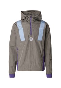 Leichte Anorak-Jacke in Grau mit hellblauen Schulterpaneelen und lila Akzenten. Mit einem halben Reißverschluss vorne und einer Kapuze.