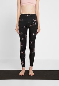 Schwarze Leggings mit floralem Muster, das rosa Flamingos und grüne Blätter zeigt, aus elastischem Material mit hohem Taillenbund.