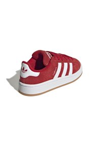 Sneaker in suede rosso con tre strisce bianche e logo, suola in gomma bianca, battistrada in gomma e design a punta rotonda. Leggere e con colletto imbottito.