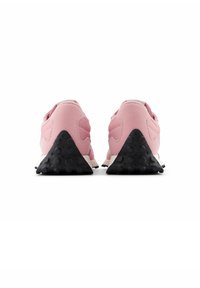 Ein Paar pinke Sneakers, von hinten betrachtet, mit dicken, strukturierten schwarzen Keilabsätzen auf einem weißen Hintergrund.