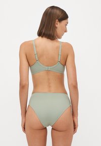 Lichte groene bikini set, met een eenvoudig ontwerp, verstelbare bandjes, een gladde textuur en een hoogblokje voor extra bedekking.